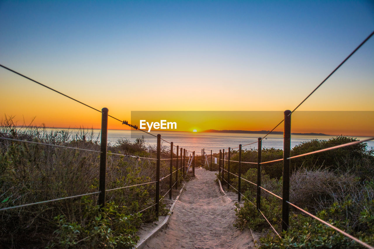 Enjoying an ocean sunset view from a hiking trail along the southern california coast. 