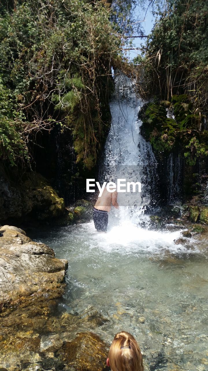 High angle view of man enjoying at waterfall