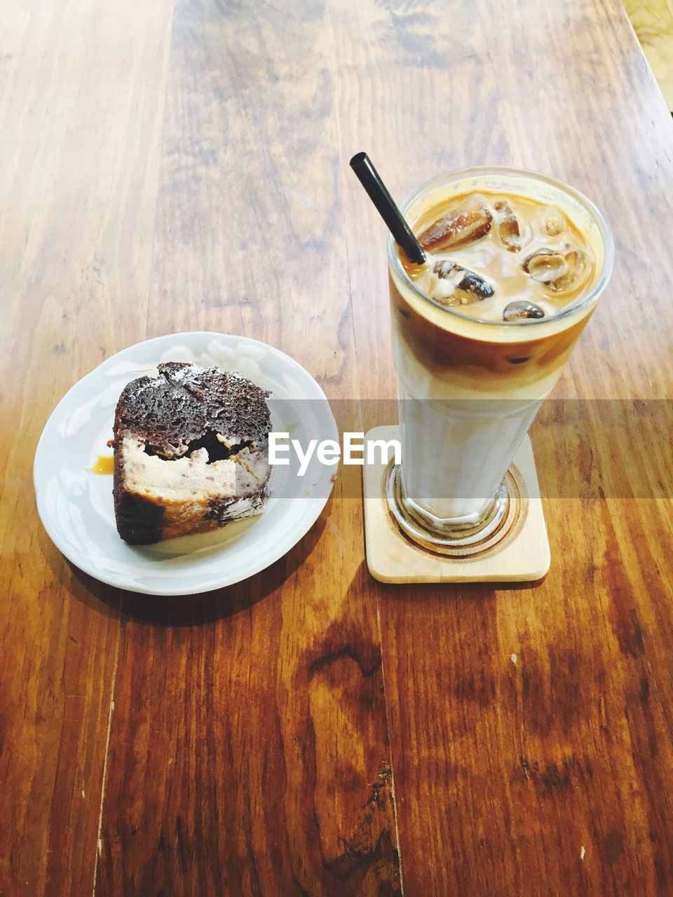 High angle view of cold coffee with cake served on table