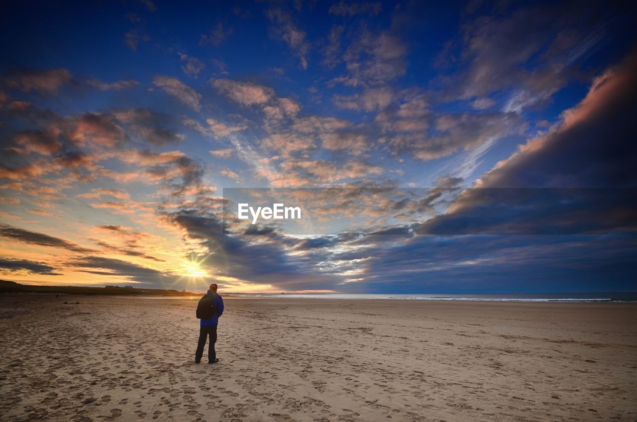 Rear view of man standing at beach