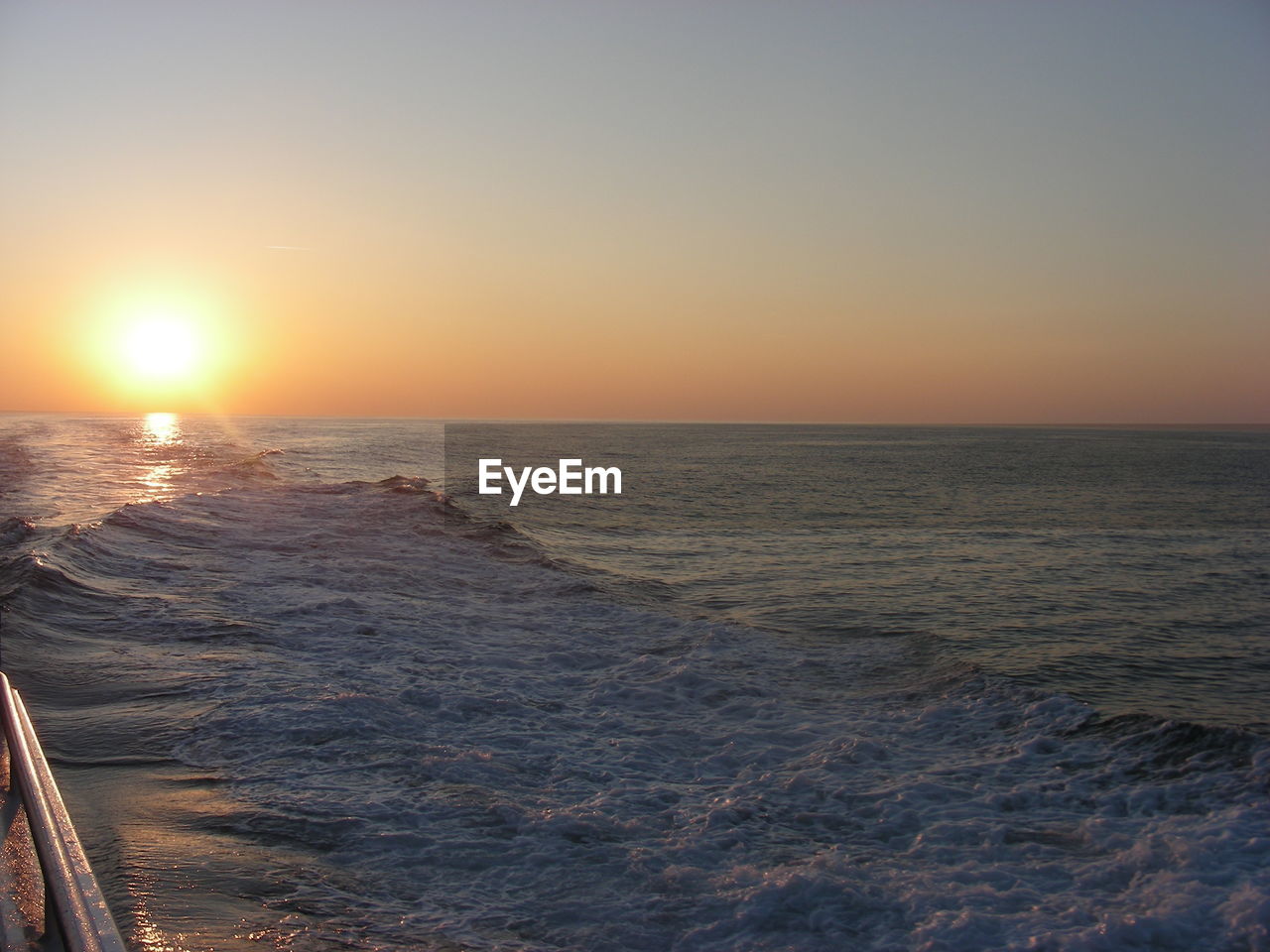 SCENIC VIEW OF SEA AGAINST CLEAR SKY AT SUNSET