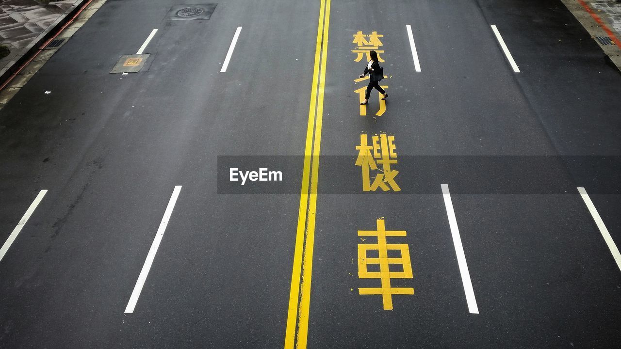 High angle view of woman crossing road