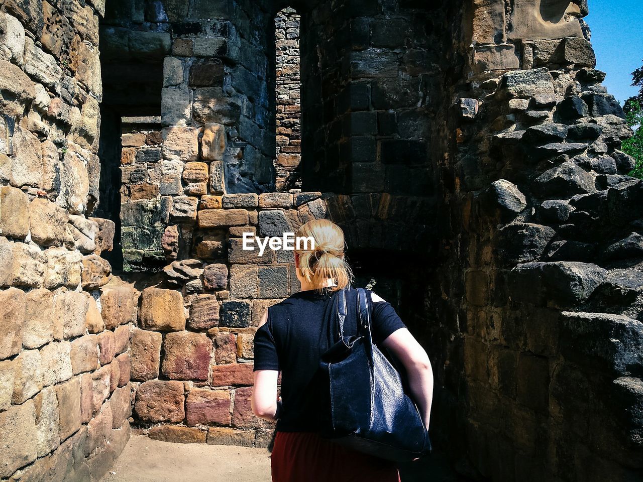 Rear view of woman standing at abbey ruins