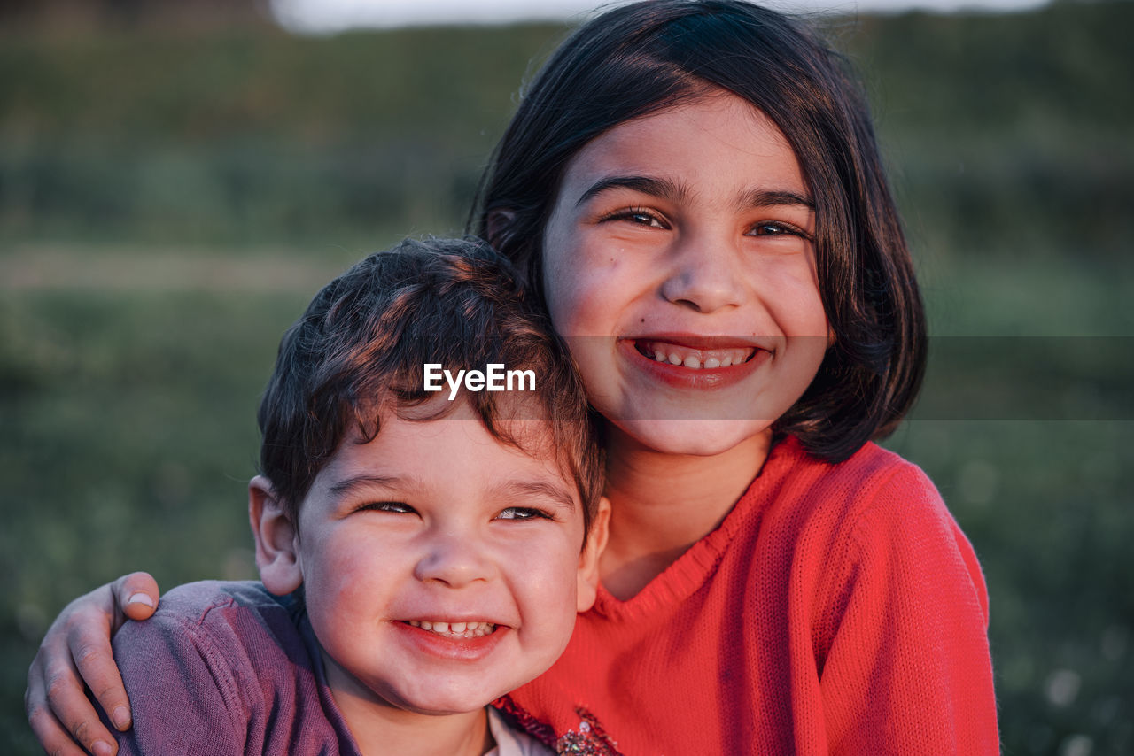 Cute siblings smiling outdoors