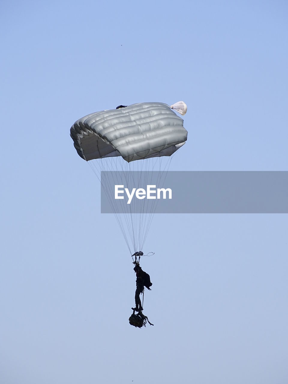 LOW ANGLE VIEW OF PERSON PARAGLIDING OVER CLEAR SKY