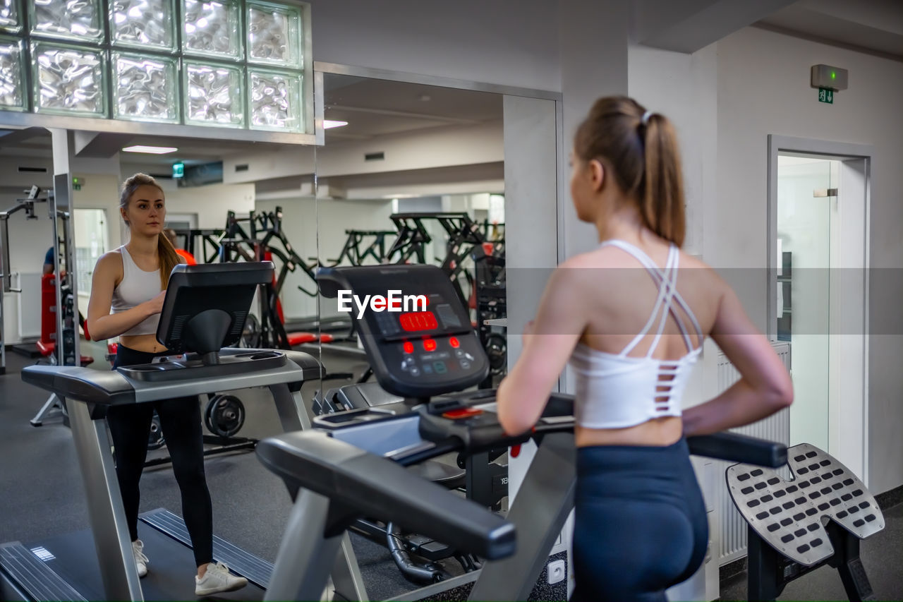 rear view of young woman exercising at gym