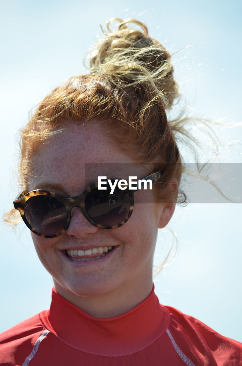 PORTRAIT OF YOUNG WOMAN WEARING SUNGLASSES
