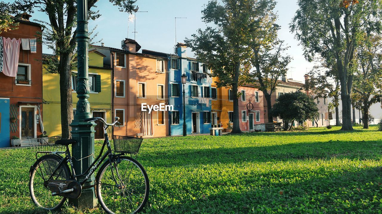 Bicycle by house against sky