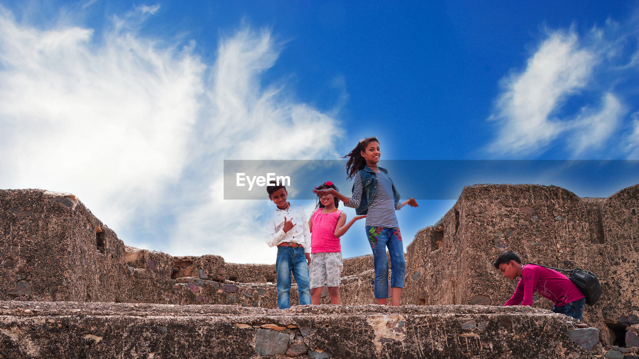 People standing on mountain against sky