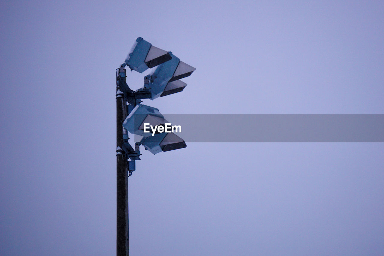 Low angle view of floodlights against clear sky during winter