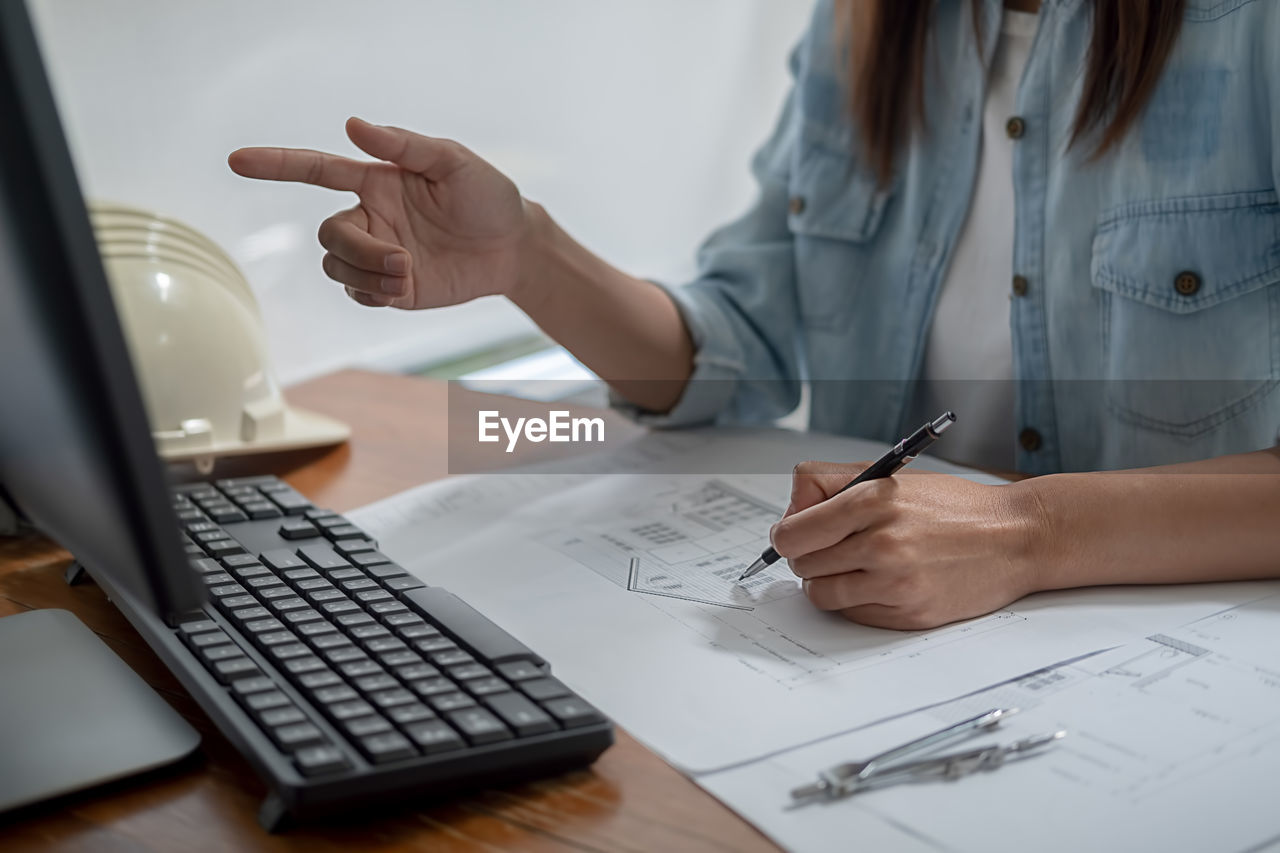 Midsection of architect working on table in office