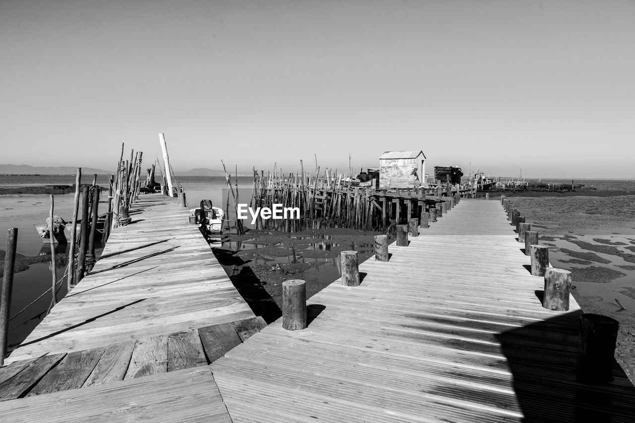 Wooden pier over sea against clear sky