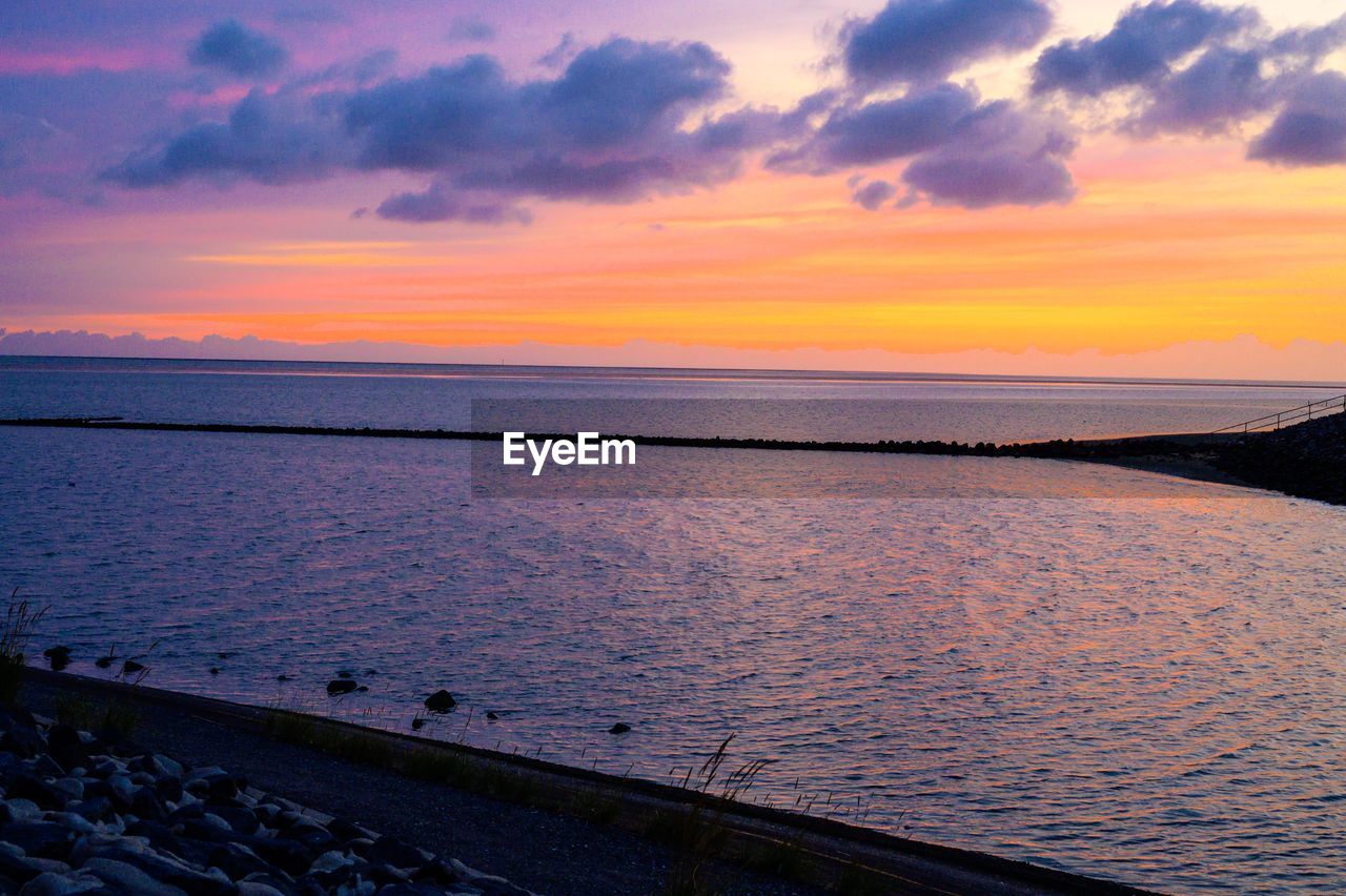 SCENIC VIEW OF SEA AGAINST SKY AT SUNSET