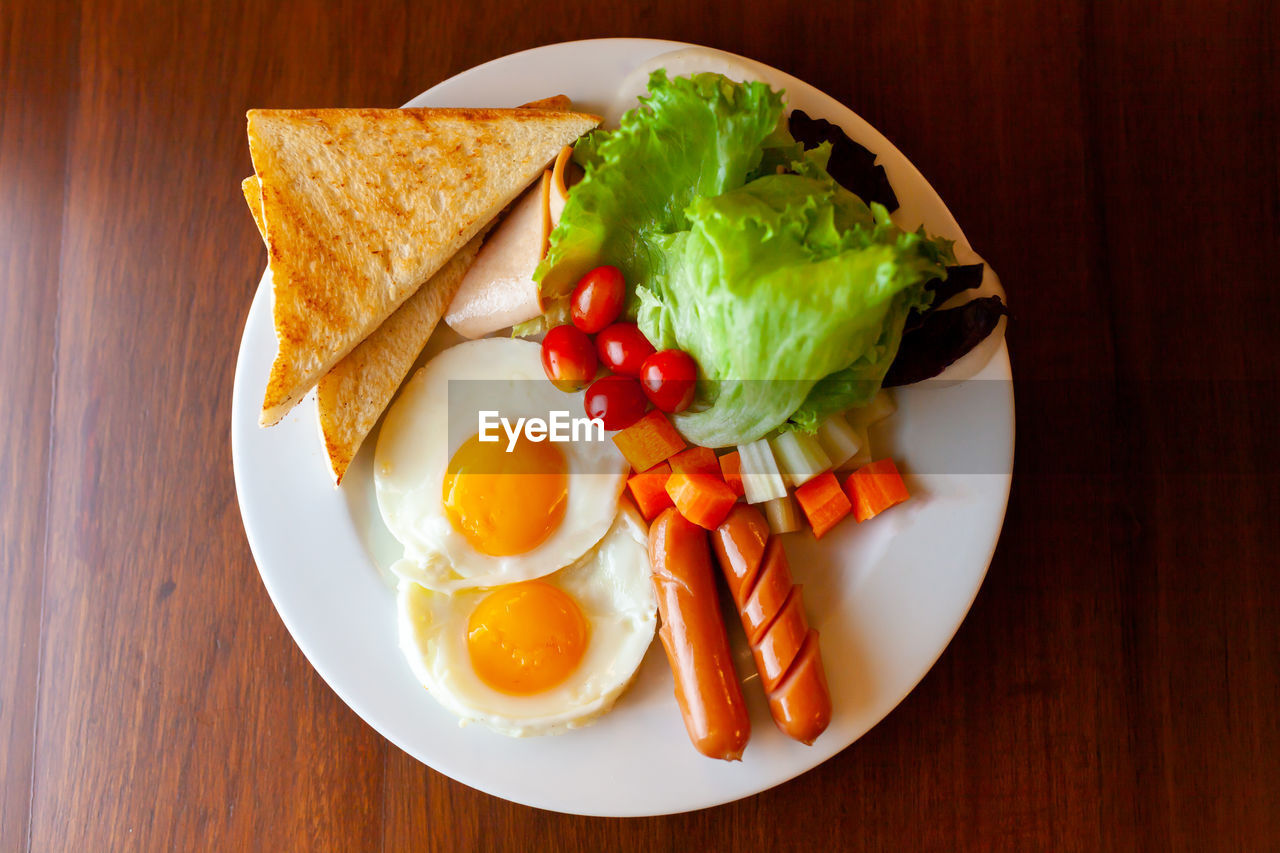 Full american breakfast. sunny side fried eggs, roasted bacon, hash brown and toasts