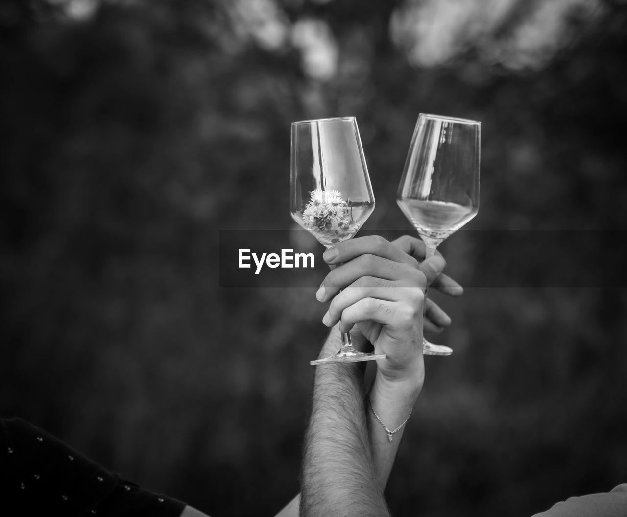 Black and white photo, tow hands with empty wine glasses