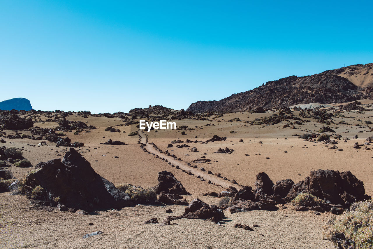 Scenic view of rocky mountains against clear blue sky