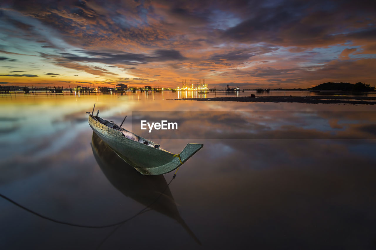 BOAT MOORED ON SEA AGAINST SKY DURING SUNSET