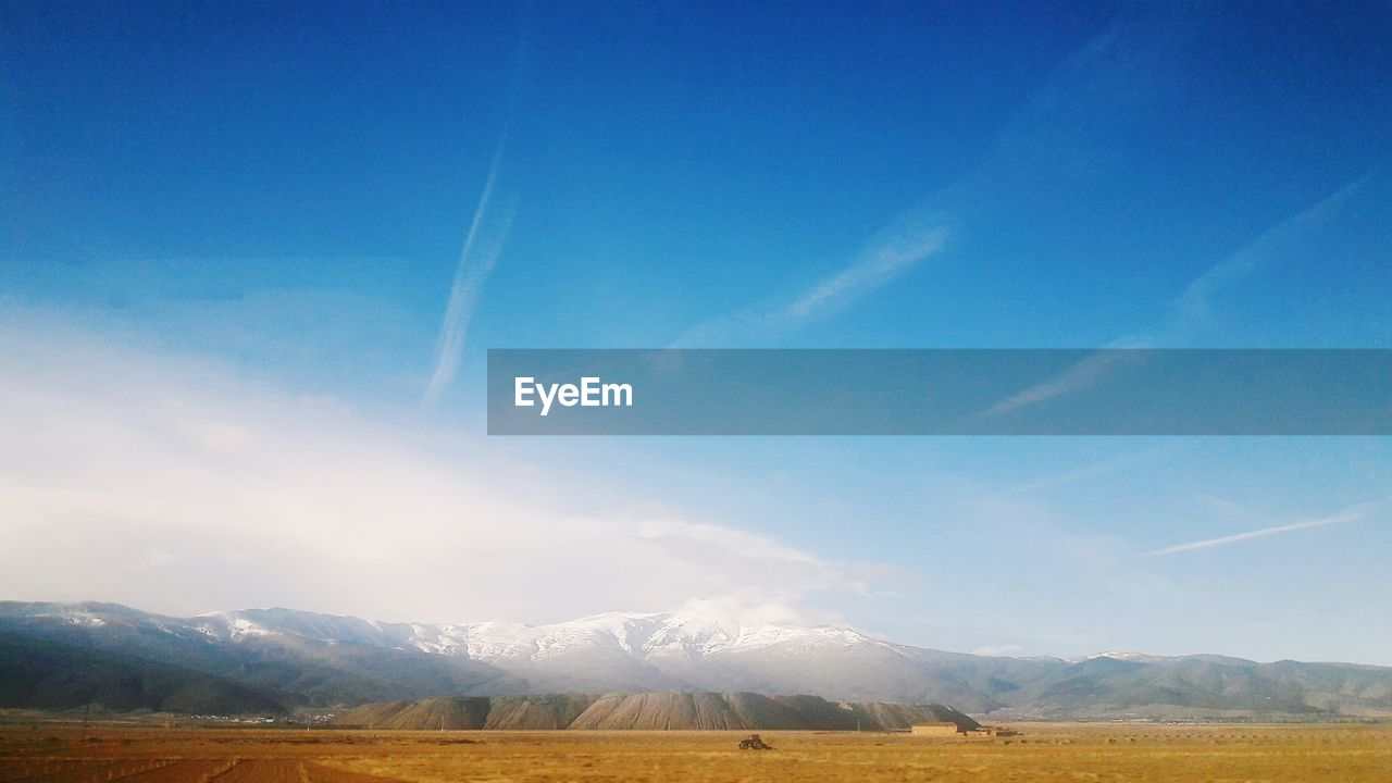 Scenic view of field against blue sky