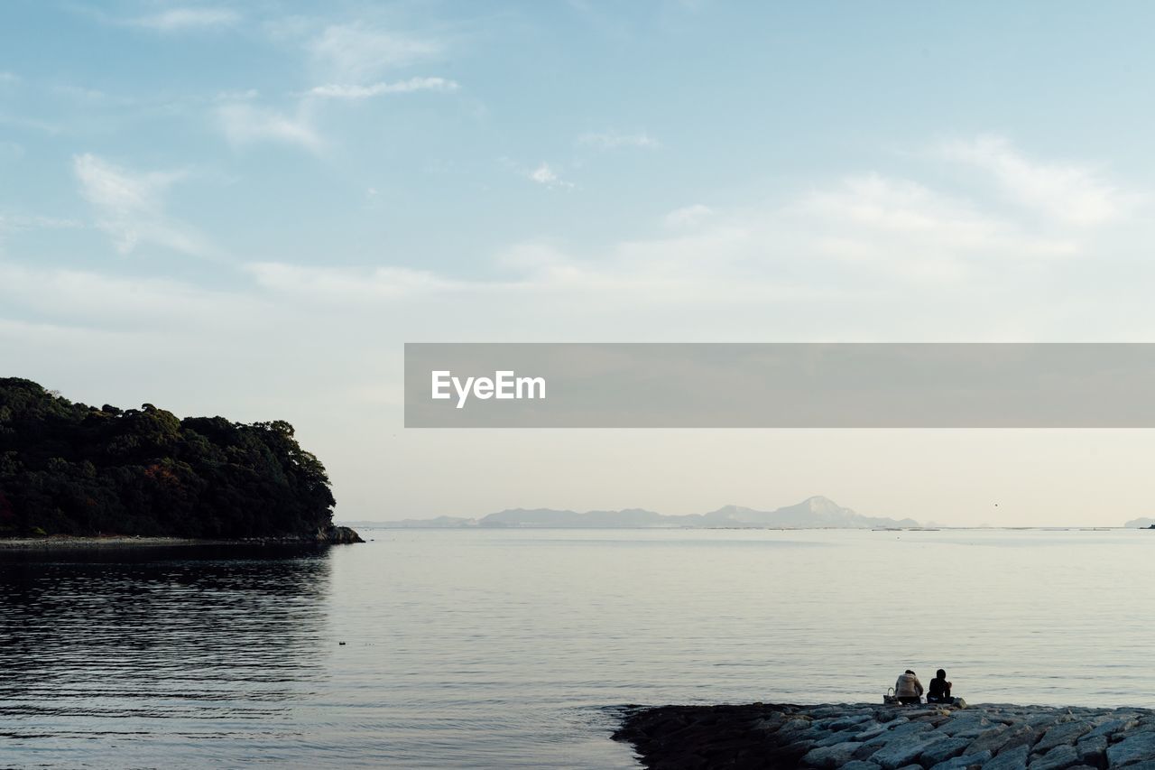 SCENIC VIEW OF SEA BY ROCKS AGAINST SKY