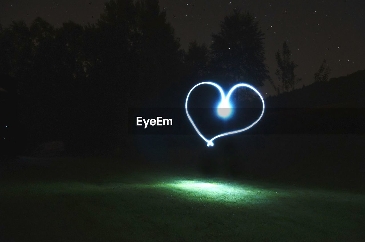 Heart shaped light painting on field at night