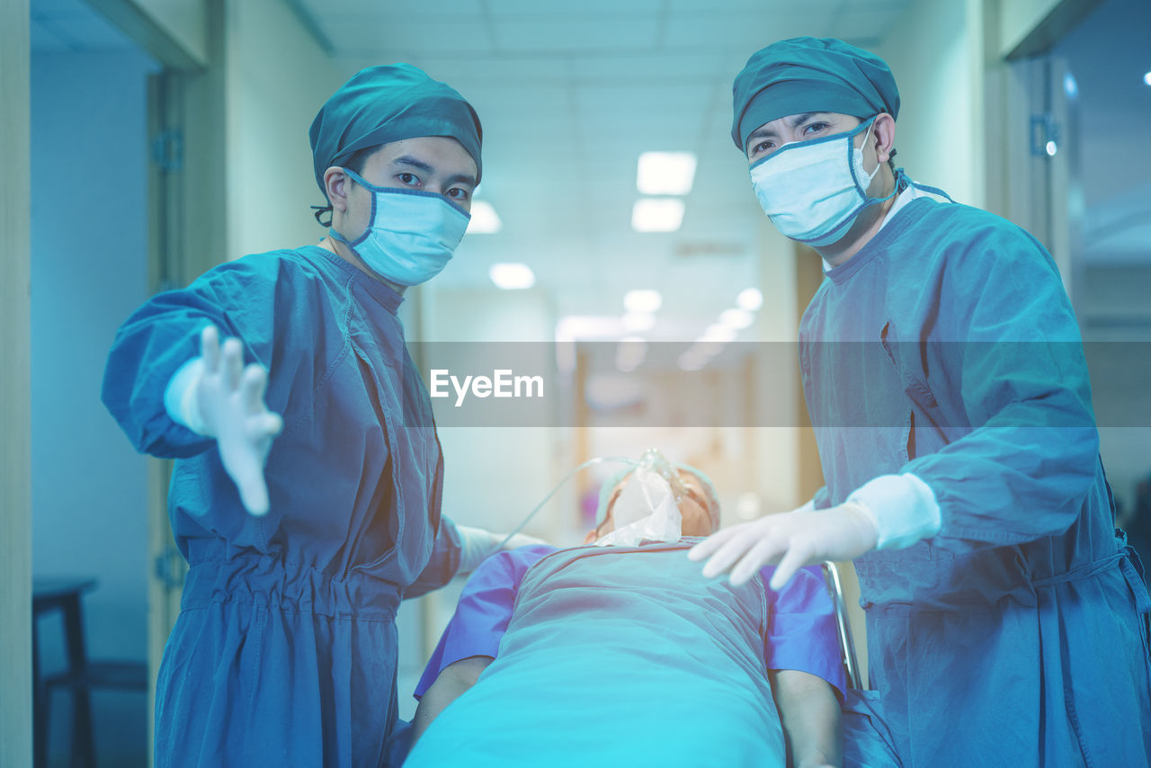 Doctor getting their patient ready for the next procedure in the corridor, a medical team.