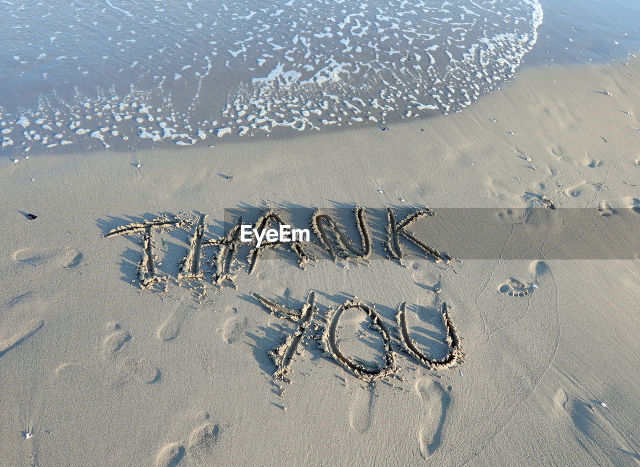 HIGH ANGLE VIEW OF TEXT ON SHORE