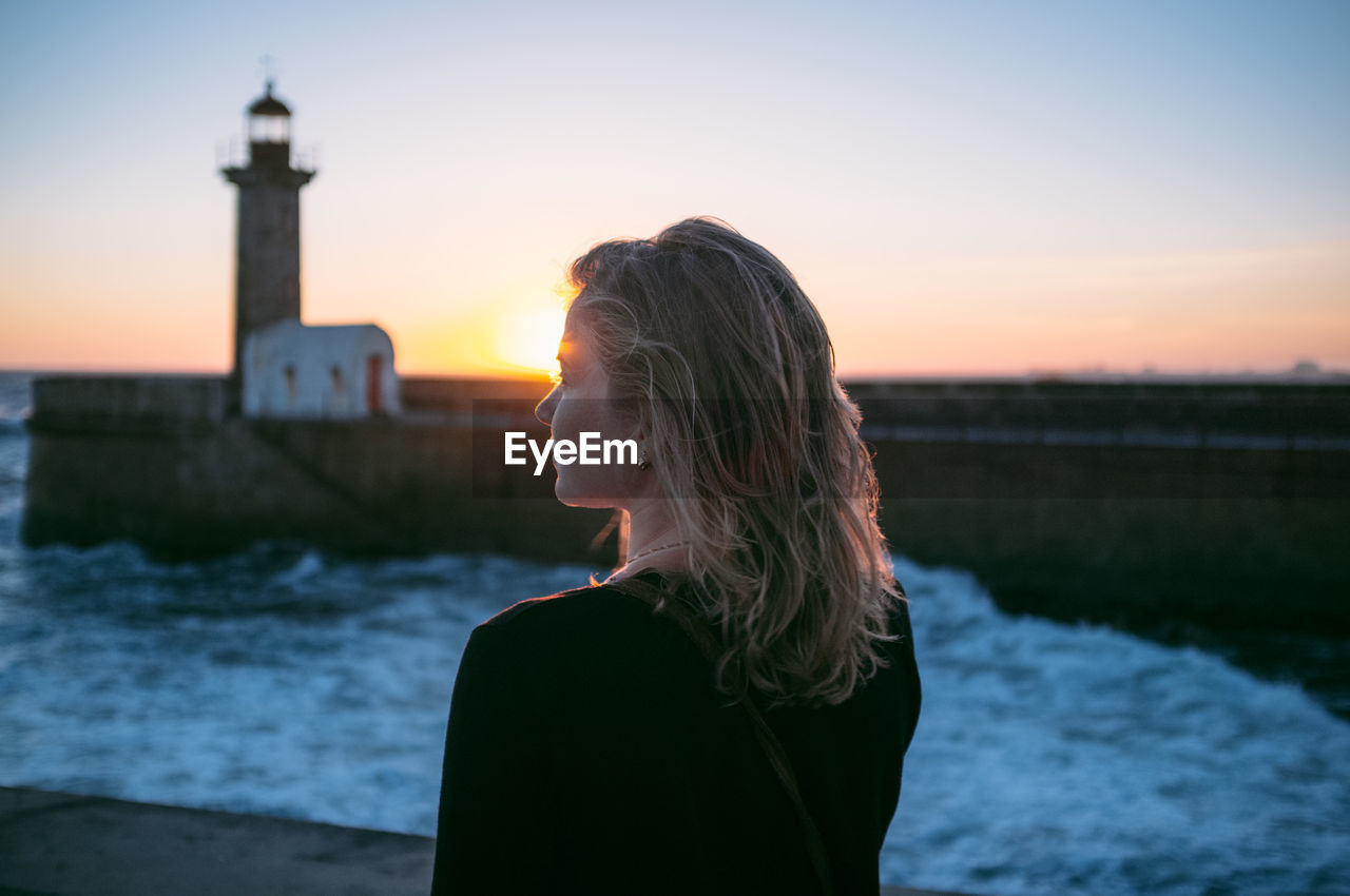 Rear view of woman looking at sunset