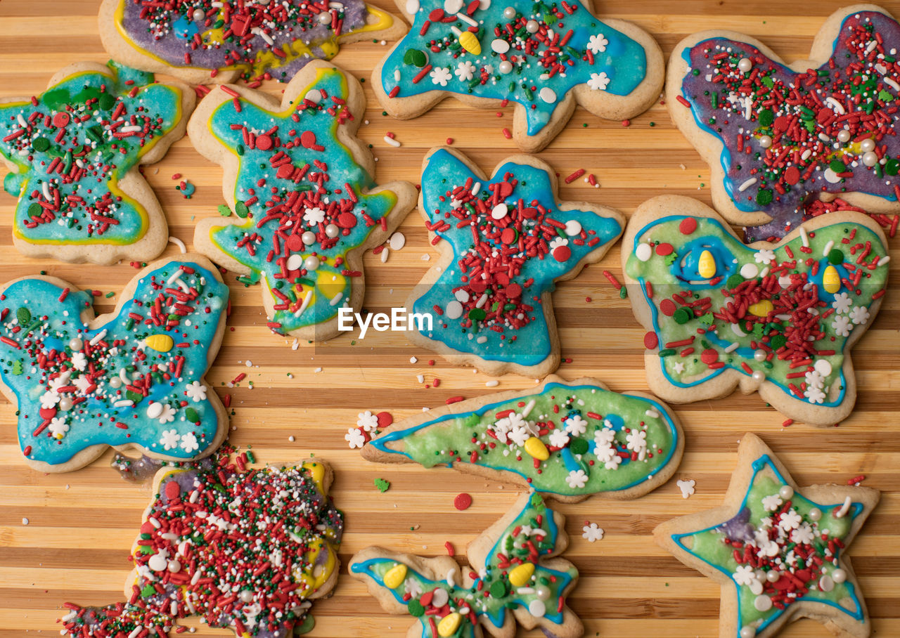 Christmas cookies in a variety of shapes and frosted with a variety of colors and sprinkles laid out