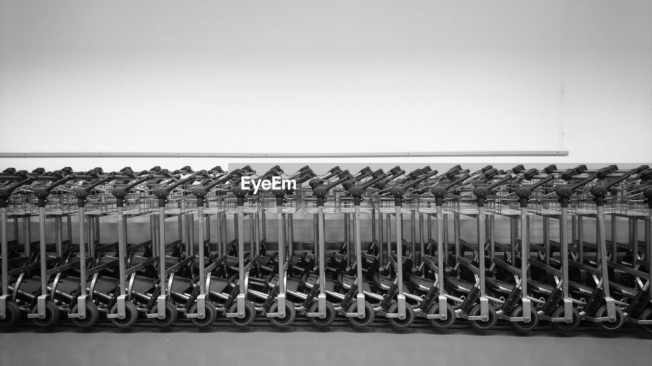 Row of shopping carts against clear sky