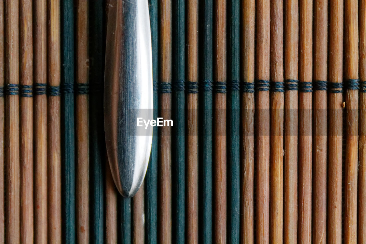 Close-up of spoon on straw mat