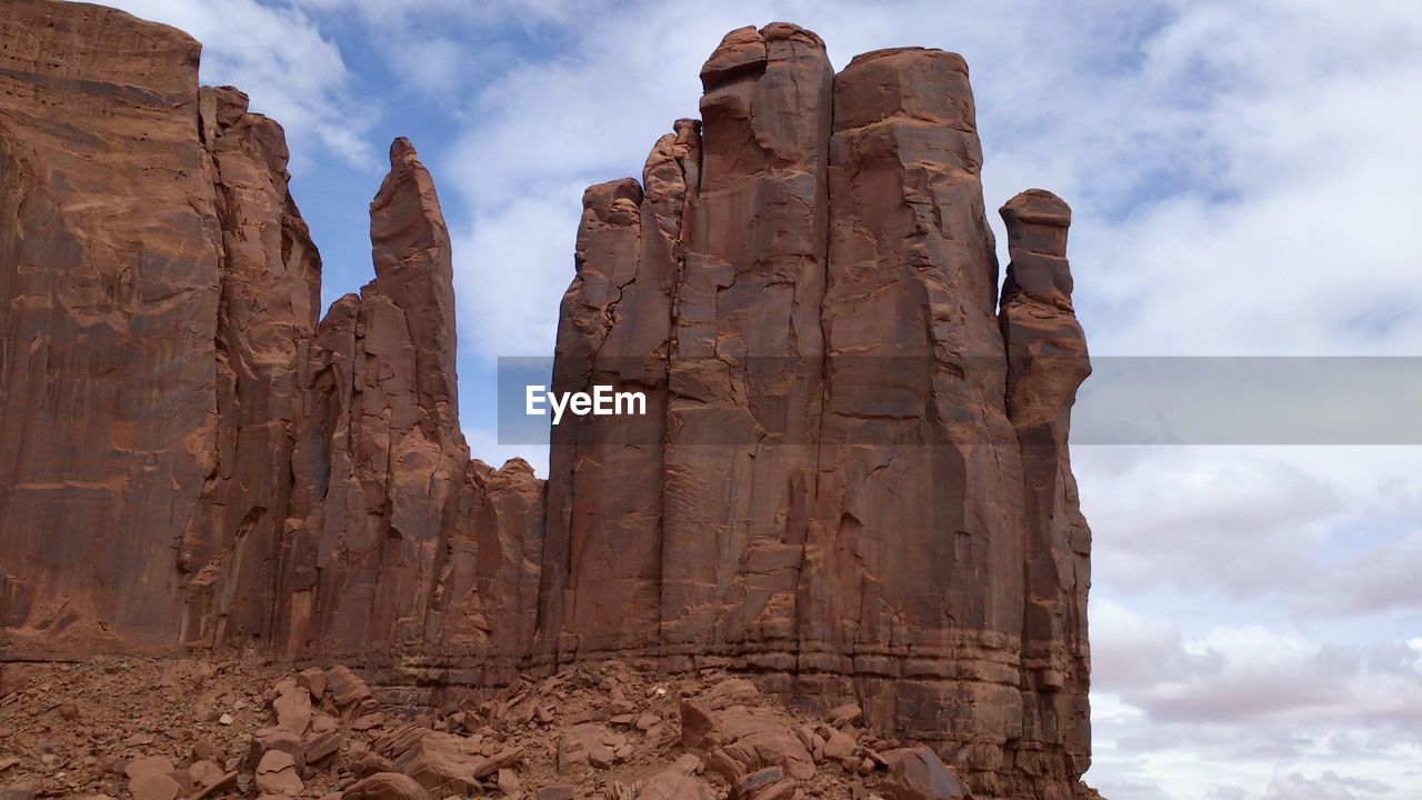 Low angle view of rock formation against cloudy sky