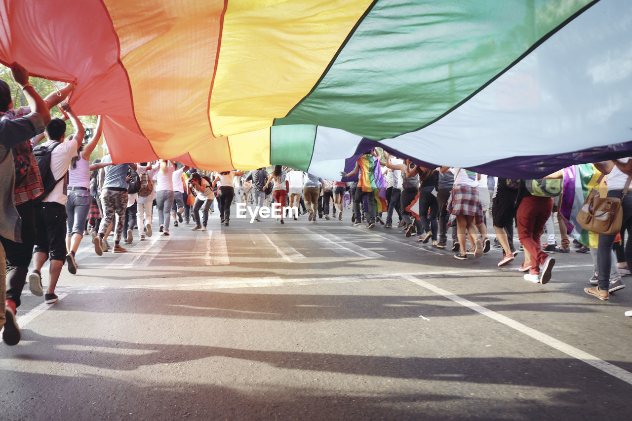 People holding flag while running on road