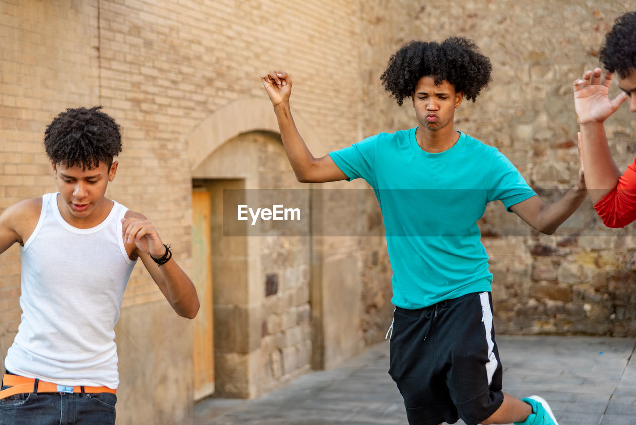 Group of afro latin male friends dancing in the street