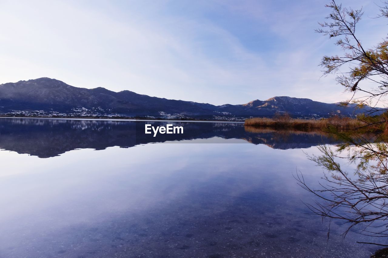 SCENIC VIEW OF LAKE BY MOUNTAIN AGAINST SKY