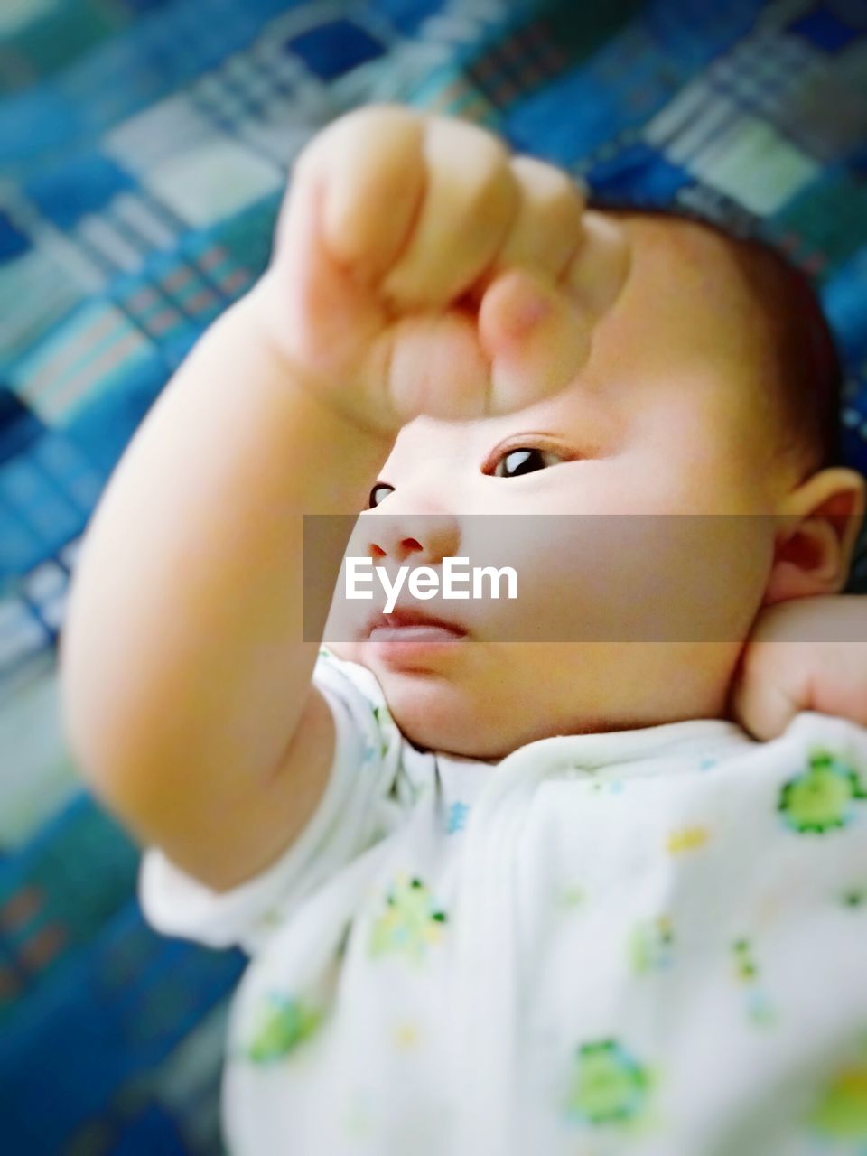 High angle view of cute baby girl lying on bed at home