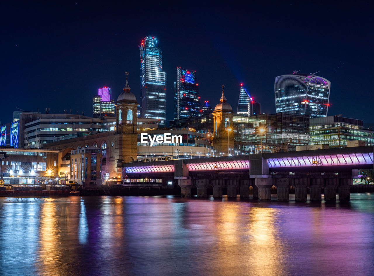 Skyline of london at night  illuminated bridge over thames river and city of london 