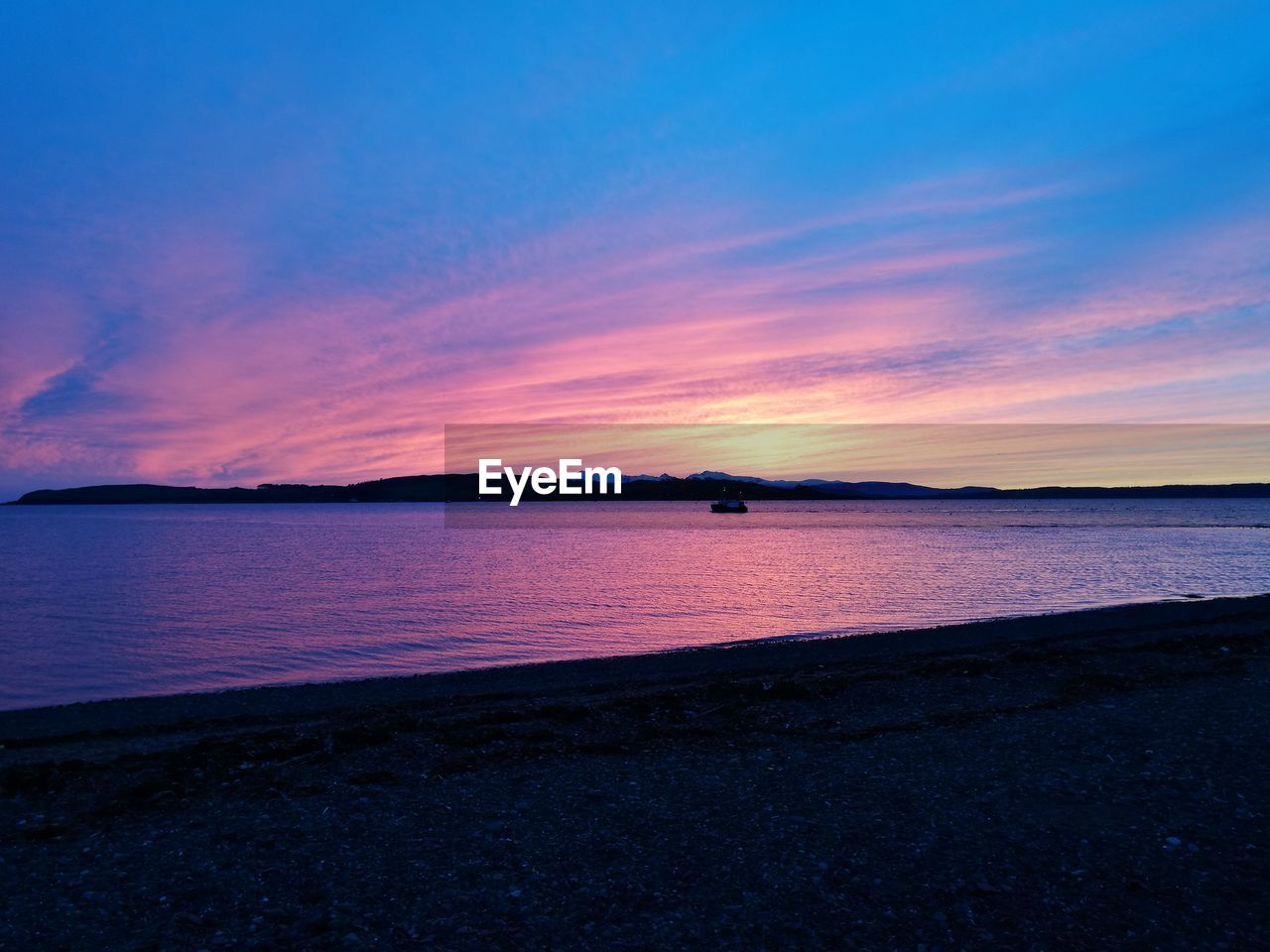 SCENIC VIEW OF BEACH AGAINST SKY AT SUNSET