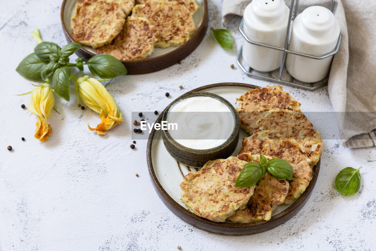 Zucchini fritters. vegetarian zucchini pancakes with cheese, served with sour cream