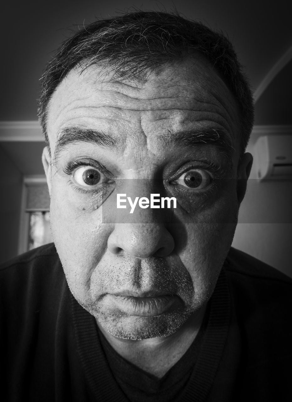 Astonished adult male close-up face, black and white portrait