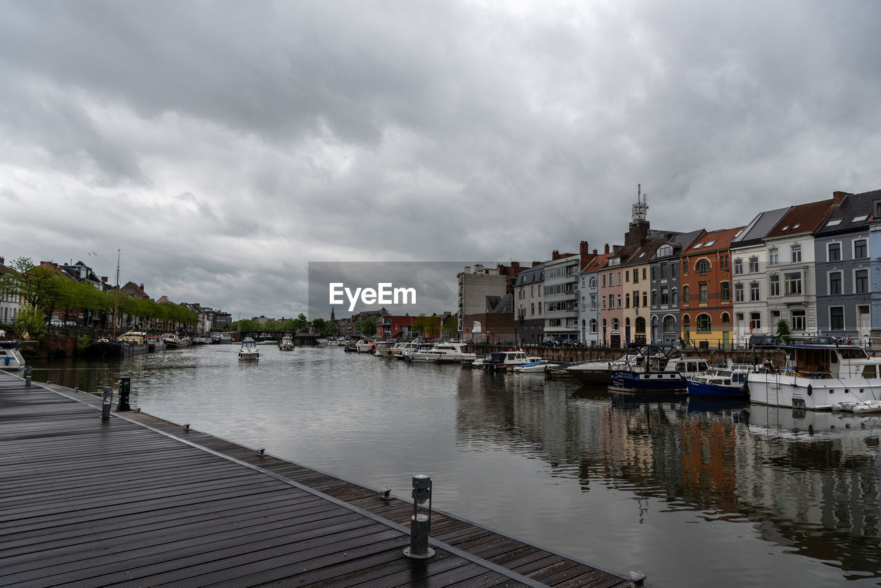 BUILDINGS BY RIVER AGAINST SKY