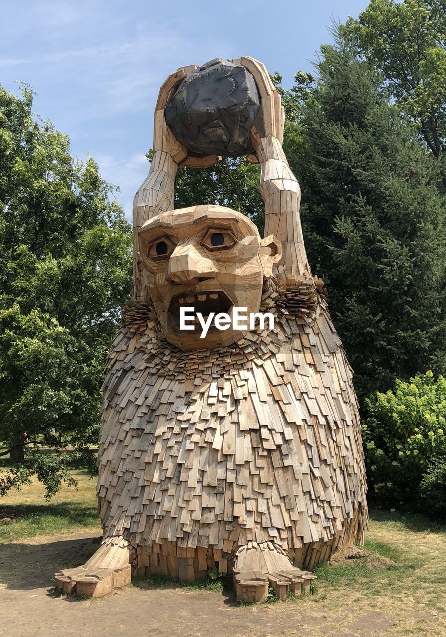 STATUE AGAINST TREE TRUNK