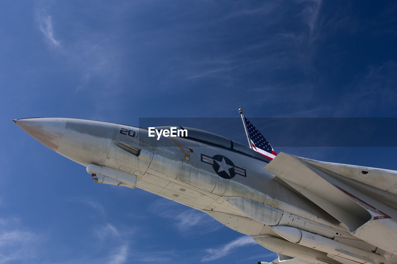 Low angle view of fighter airplane flying against blue sky