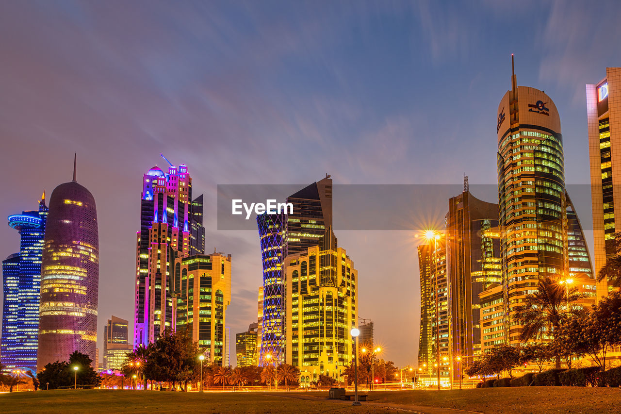 ILLUMINATED CITY BUILDINGS AT NIGHT