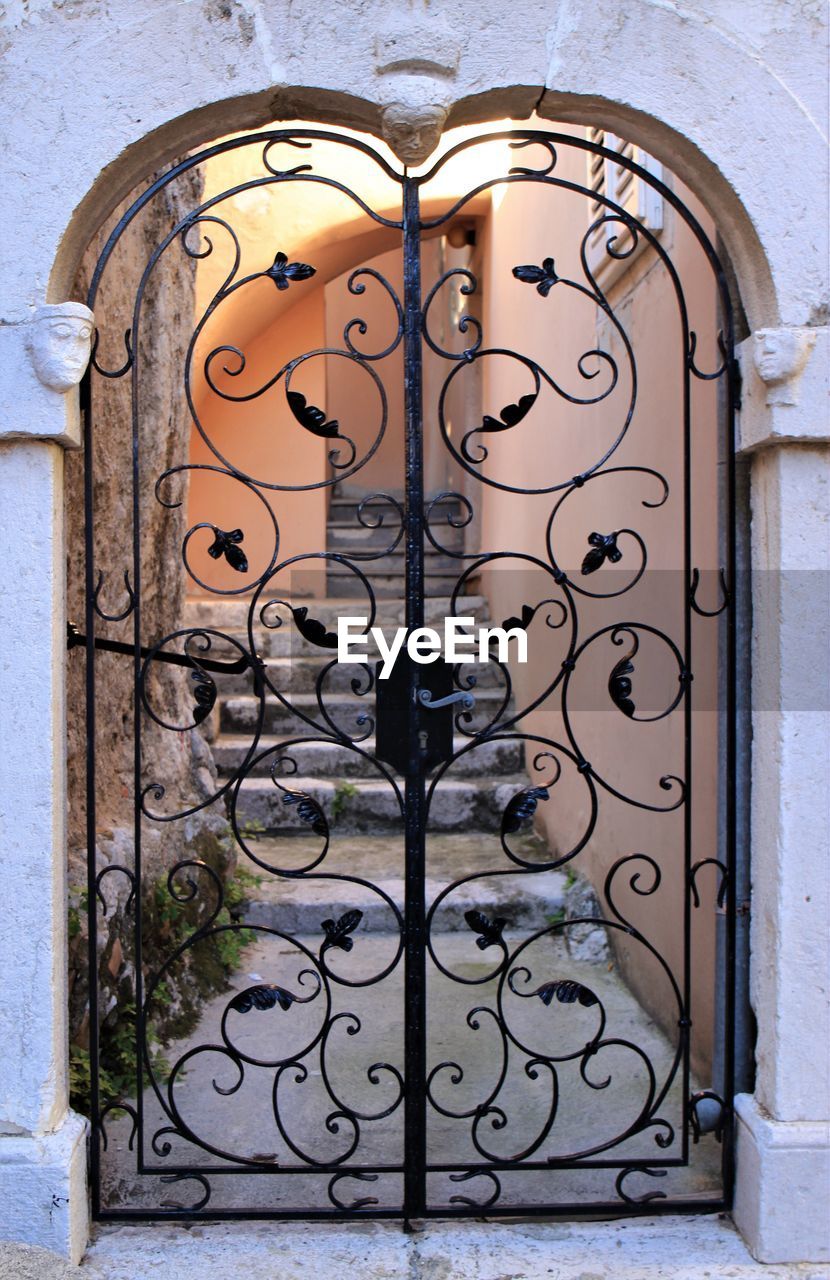 CLOSE-UP OF METAL GATE AGAINST DOOR