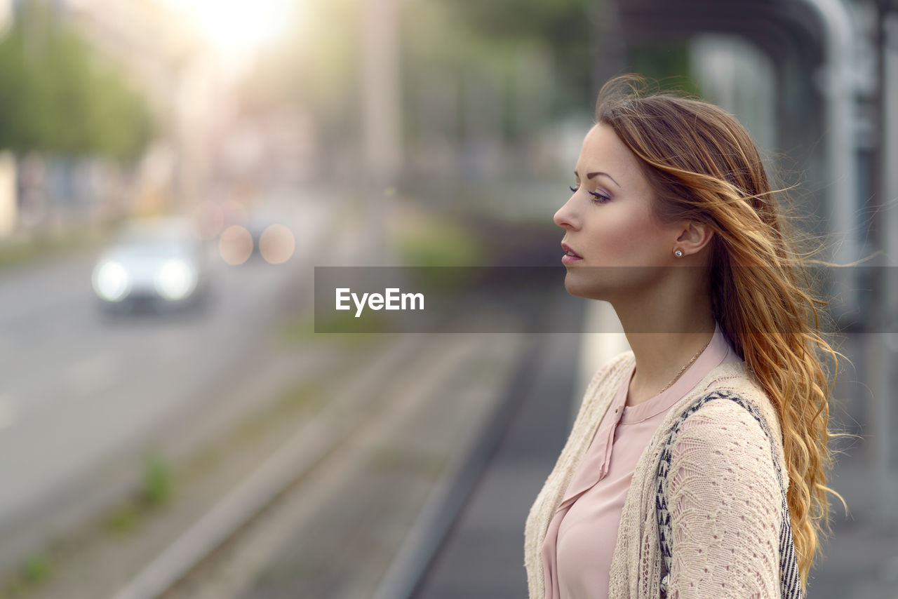 Side view of thoughtful woman standing on roadside