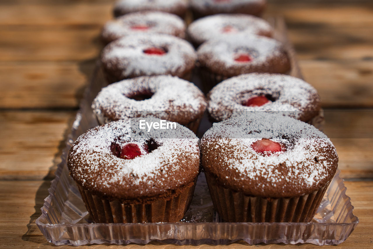 CLOSE-UP OF CUPCAKES ON TABLE AGAINST WALL