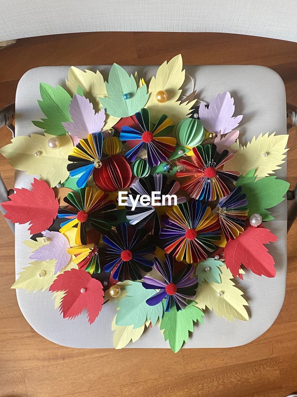 multi colored, flower, table, indoors, high angle view, creativity, directly above, art, no people, still life, wood, craft, origami paper, petal, paper, wheel, variation, flowering plant, arrangement, close-up, large group of objects, origami, plate