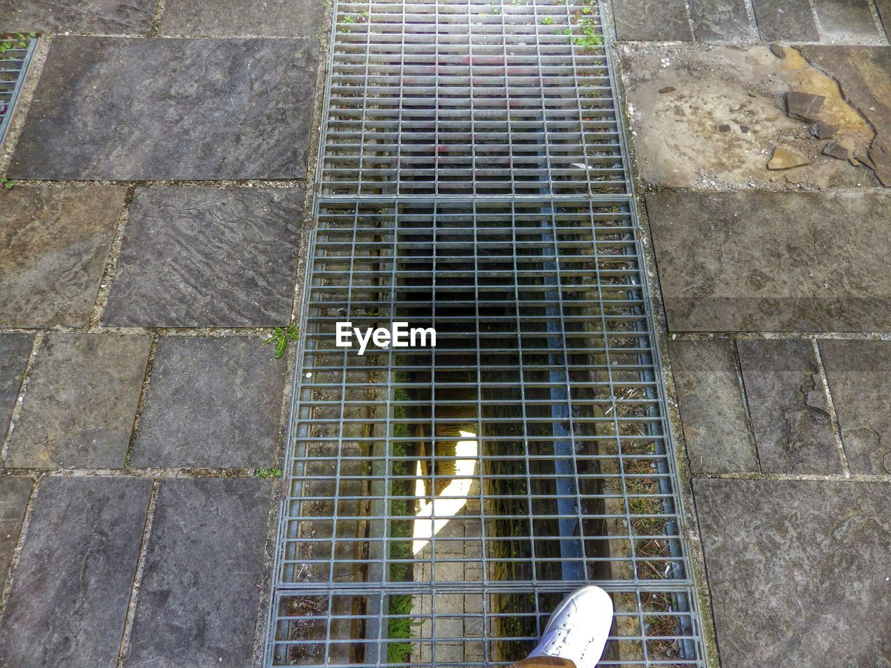 Low section of man standing on manhole