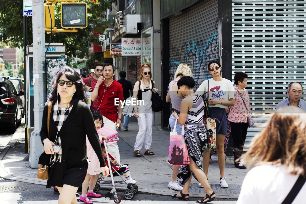 PEOPLE WALKING ON ROAD IN CITY