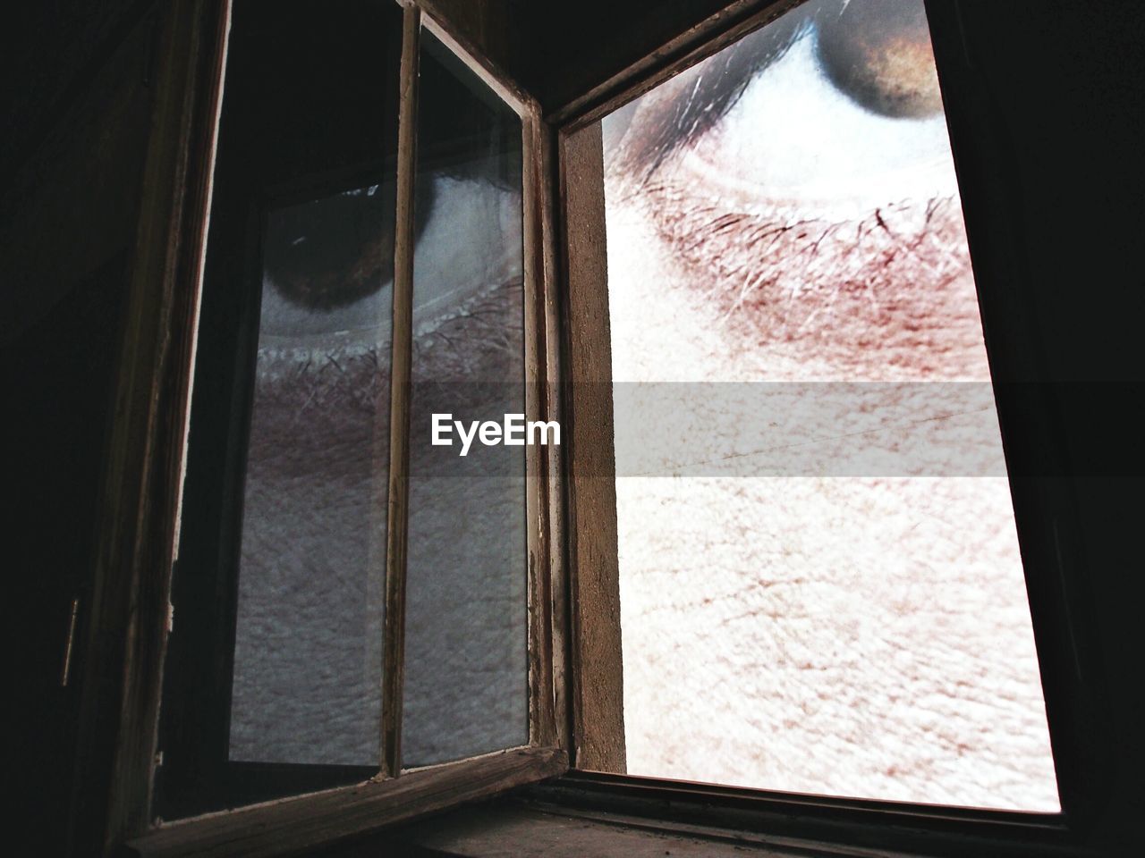 Cropped image of eye seen from window